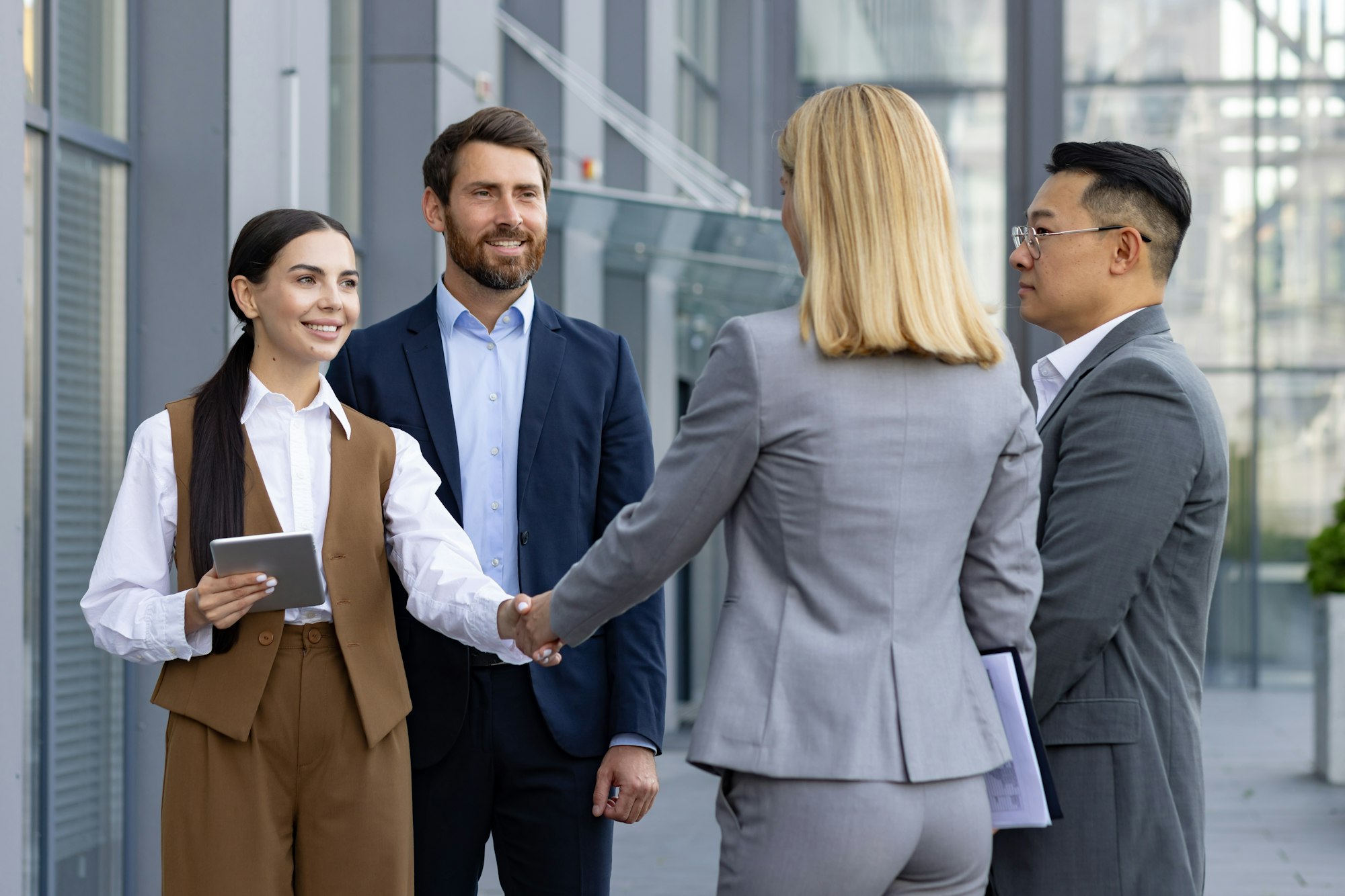 Professional team handshake at modern office building: Collaboration and partnership