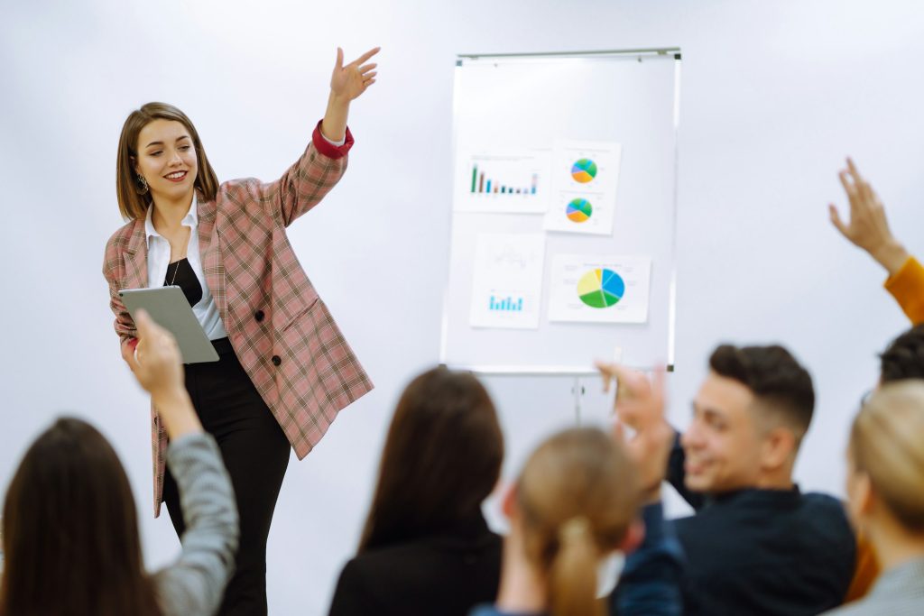 Young woman coach speaker giving flipchart presentation, speaker leading training